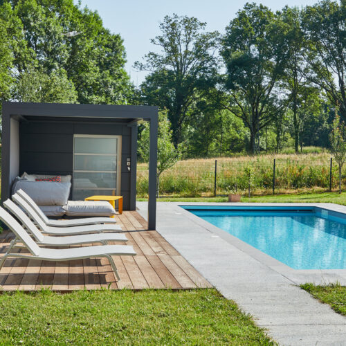 Aménagement tour de piscine bois, béton balayé et pool house